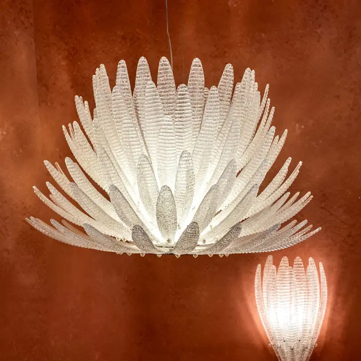 Ruddles chandelier of white glass petals against a terracotta wall