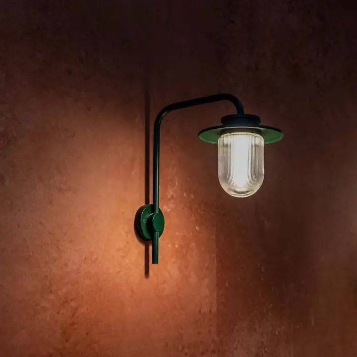 Tron wall light on a curved arm against a terracotta wall